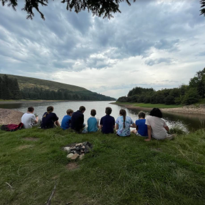 students sat by a lake