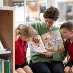 students listening to a teacher read a book