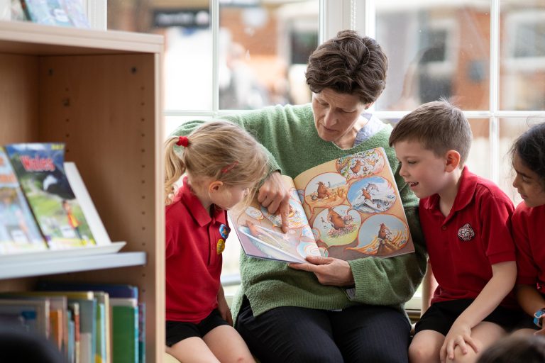 students listening to a teacher read a book