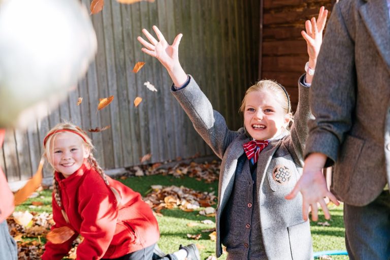 girl throwing leaves in the air