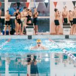 students looking at 1 student swimming in the pool