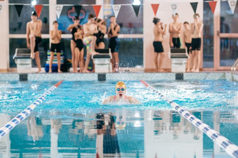 students looking at 1 student swimming in the pool