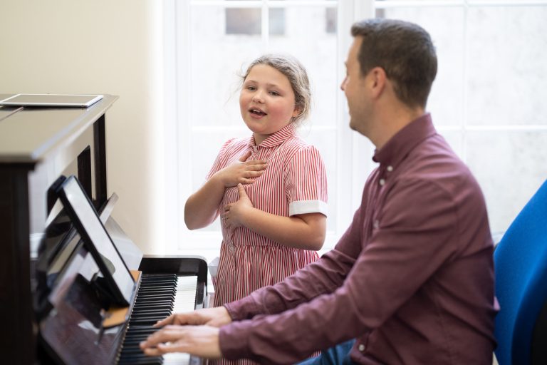 student singing with the piano being played by a teacher