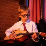 student playing the acoustic guitar