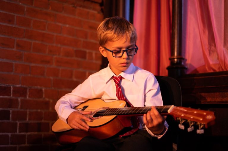 student playing the acoustic guitar