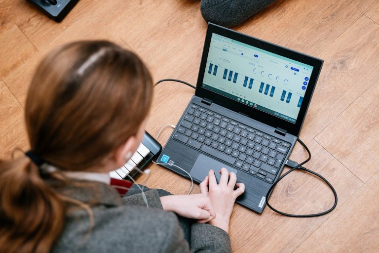 student using a laptop connected to a keyboard