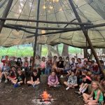 large group of students under a tipi