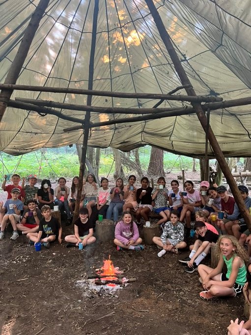 large group of students under a tipi