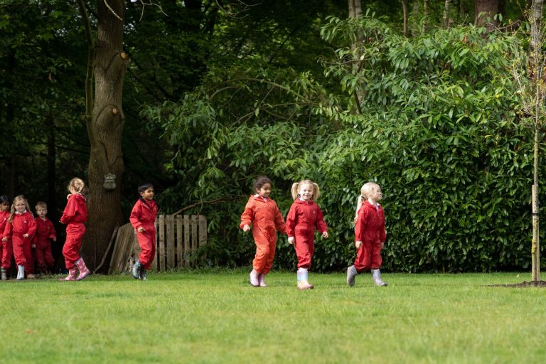 students in red jumpsuits walking along the grass