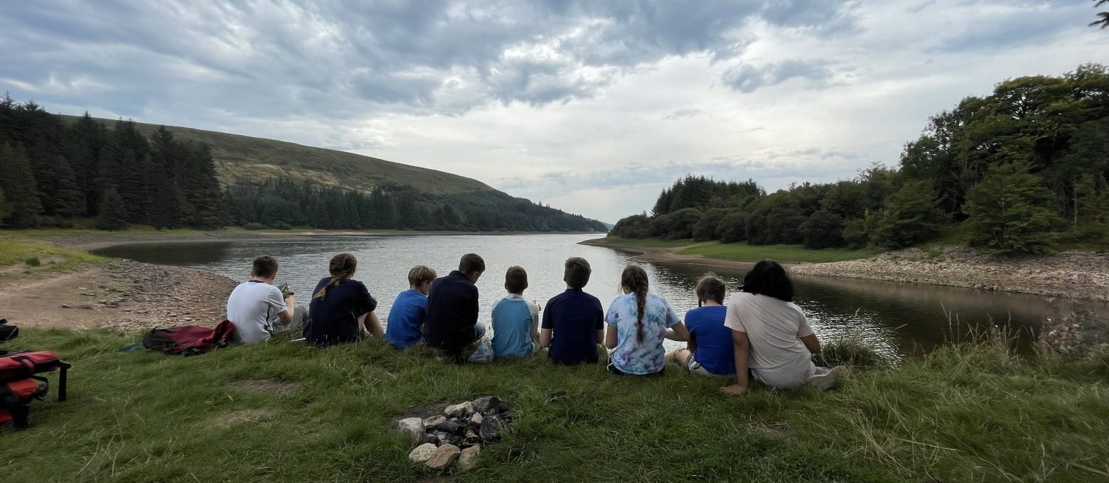 students sat by a lake